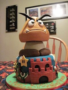 a cake made to look like a cartoon character sitting on top of a table with a chair in the background