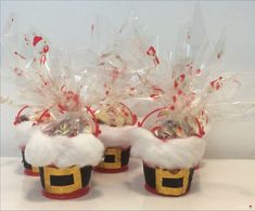 two santa claus cupcakes with candy in them