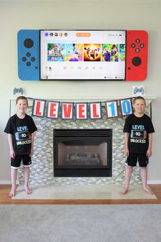 two young boys standing in front of a fireplace with nintendo wii t - shirts on