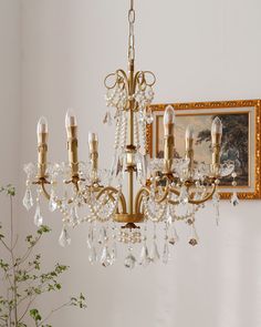 a chandelier hanging from the ceiling in a room with paintings on the wall