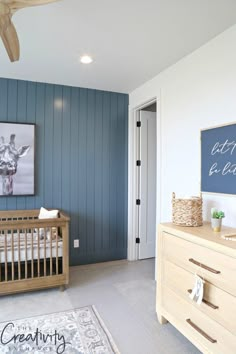 a baby's room with blue painted walls and white crib in the foreground