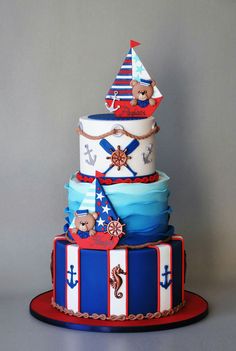 a three tiered cake with an anchor and ship on the top is decorated in red, white, and blue