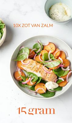 a white bowl filled with salad next to another bowl full of vegetables and sauces