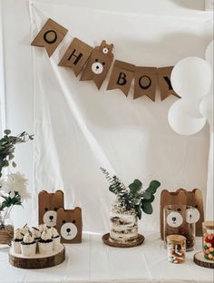 a table topped with cakes and desserts covered in brown paper letters that spell out oh boy