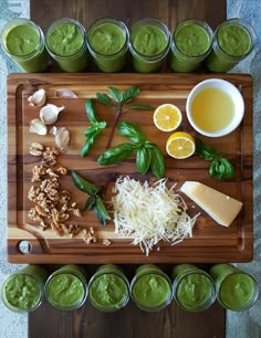 the ingredients to make this green smoothie are displayed on a cutting board with cups and spoons