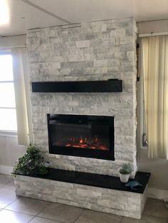 DIY Fireplace with Ledger Stone White Stone Fireplace With Black Mantle, Stone Fireplace With Black Mantle, Tile And Stone Fireplace, Light Gray Stone Fireplace, Black And White Stone Fireplace, Black And White Chimney, Grey Stacked Stone Fireplace, Electric Fireplace Ideas With Stone, Stone Ledger Fireplace