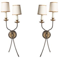 two wall lamps with white shades on them