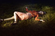 a woman laying in the grass with her arms outstretched