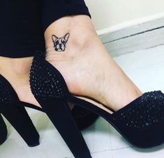 a woman's foot with a small dog tattoo on her left ankle and heel