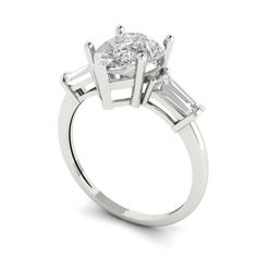 a three stone engagement ring with baguetts on the shoulders and side stones in white gold