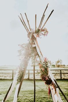 a teepee with flowers and greenery on it