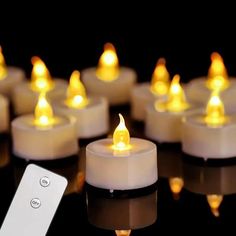 many lit candles with remote controls on the table