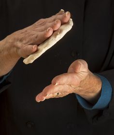 a person holding something in their hands with one hand and the other on his thumb