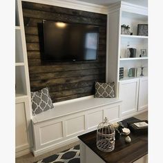 a tv mounted on the wall in a living room with white wains and wood paneling