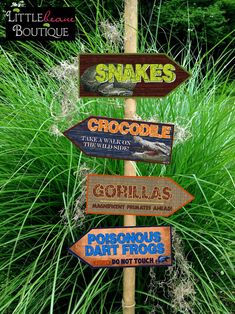 a wooden sign that has various signs on it in front of some grass and trees