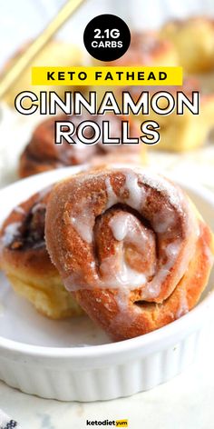 two cinnamon rolls on a white plate with the title text keto fathead cinnamon rolls