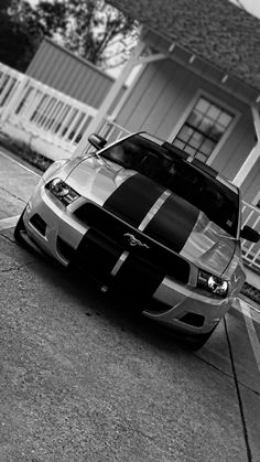 a car parked in front of a house on the side of the road with stripes painted on it