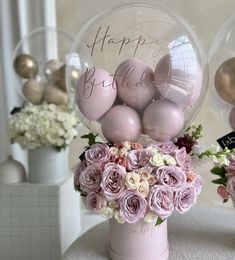 a vase filled with pink roses and balloons