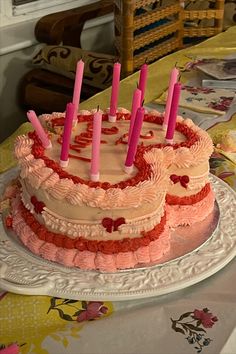 a birthday cake with pink candles on it