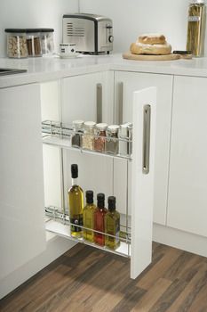 a kitchen with white cabinets and shelves filled with spices, condiments and bread