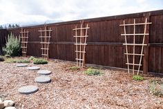 a wooden fence with stepping stones in the foreground