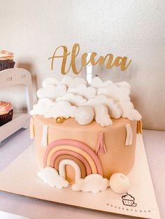 there is a cupcake with frosting on it and the name alena written in gold