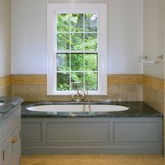 a large bathroom with marble counter tops and white walls, along with an oval bathtub