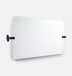 a white mirror mounted to the side of a wall next to a black hook on it