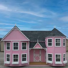 a pink doll house sitting on top of a parking lot