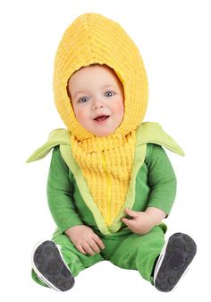 a baby wearing a corn costume sitting on the ground