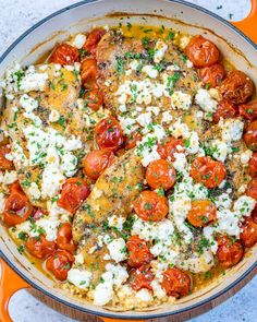 a pan filled with chicken, tomatoes and cheese