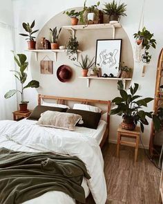 a bedroom with plants on the shelves above the bed