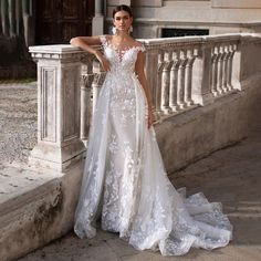 a woman in a wedding dress leaning against a wall