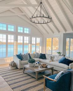 a living room filled with furniture next to a large window covered in lots of windows