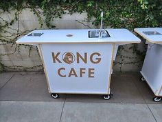 two white and gold portable kitchen carts with the words kong cafe on them