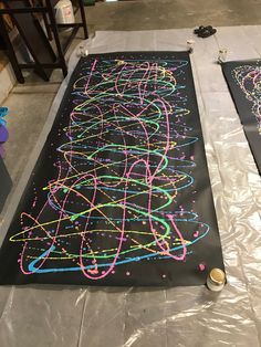 two large blackboards with neon colored writing on them sitting on top of a table