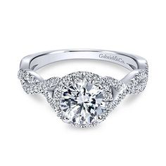 a white gold halo style engagement ring with diamonds on the band and an oval center stone