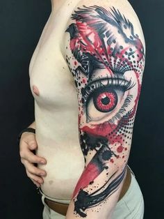 a woman's arm with an eye and bird tattoo on her left side shoulder