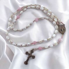 This special rosary is a lighter version of our signature Parable of Pearls Rosary. Perfect for a young girl - perhaps a Baptism or first Holy Communion. It features rice-shaped mother of pearl beads for the decades and rose quartz for the Our Fathers, as well as Czech glass shiny pink spacers, and a bronze Miraculous Medal and crucifix made in Italy. Pearl White Spiritual Rosary As Gift, Spiritual Pearl White Rosary Gift, Spiritual Pearl White Rosary As Gift, White Spiritual Rosary For Mother's Day, Spiritual White Rosary For Mother's Day, Mother's Day White Spiritual Rosary, St Michael Medal, Handmade Tapestries, Pearl Rosary