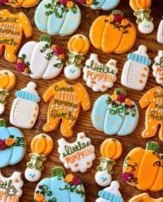 decorated cookies are arranged on a table with flowers and pumpkins in the center, along with words that read celebrate little pumpkin day