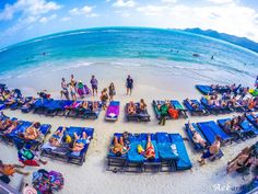 a group of people laying on top of blue beach chairs