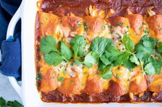 an enchilada dish is shown with cilantro and parsley