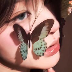 a close up of a woman with butterflies on her face