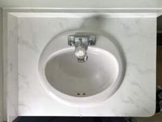 a white bathroom sink sitting under a faucet