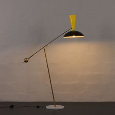 a lamp that is on top of a table next to a white wall and floor