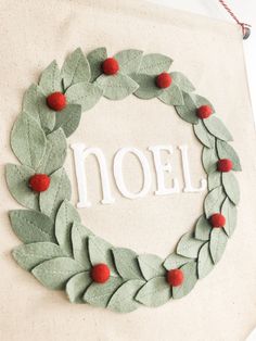 a wreath made out of felt with the word noel written on it