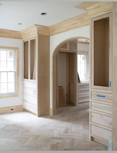 an empty room with unfinished walls and wood trim