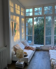 a room with two beds, a window and a radiator