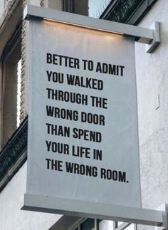 a sign hanging from the side of a building that says, better to admit you walked through the wrong door than spend your life in the wrong room