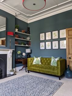 a living room with green couches and pictures on the wall above it's fireplace